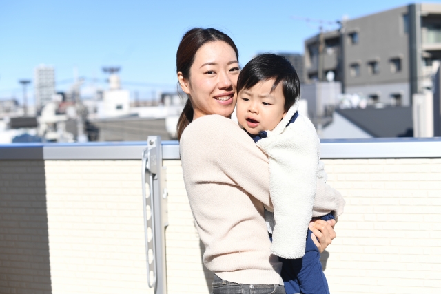 シングルマザーが子どもを抱いて暮らす街での生活イメージ。安心できる環境で子育てと仕事を両立する様子