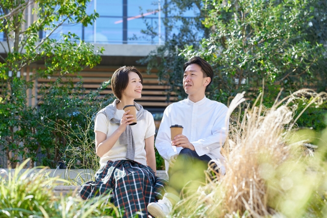 40代シングルマザーが新しい恋人と穏やかな午後を過ごす様子。安心した笑顔で会話を楽しみながら、前向きに人生を歩み始めている。