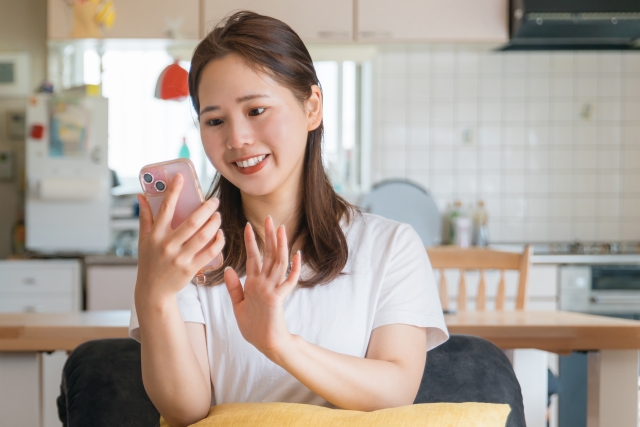 スマホで出会いアプリを使いながら笑顔でやり取りするシングルマザー