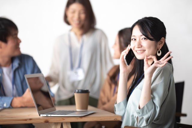 スマホで友だち作りアプリを使いながら笑顔で交流するシングルマザー。安心してつながれる環境を楽しむ様子