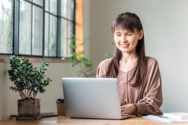 在宅ワークに取り組む50代シングルマザーがパソコンで仕事を進めている様子